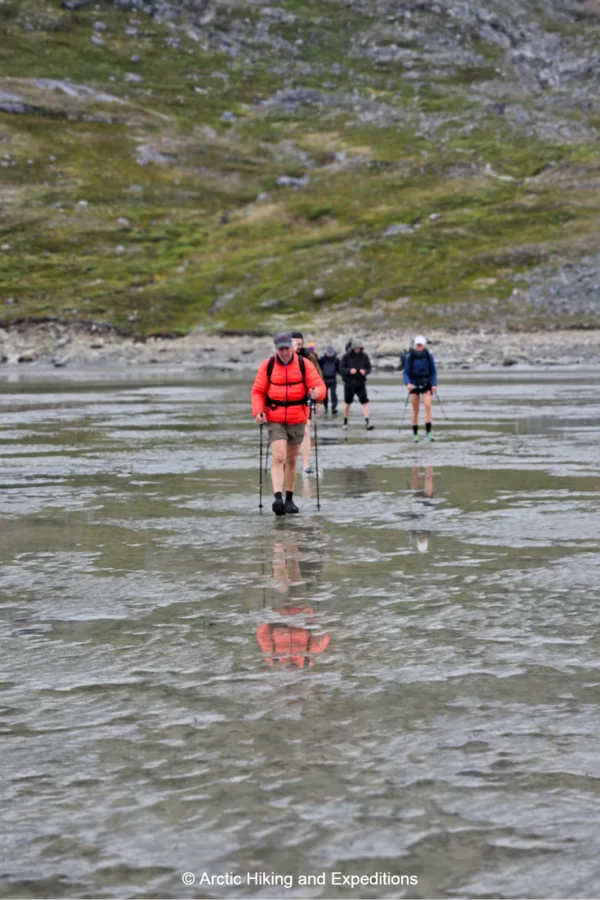 Hiking along a beach on low tide in the Sermilik fjord East Greenland