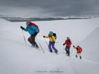 Snowshoers climbing up a hill near Sermilik ice fjord in East Greenland