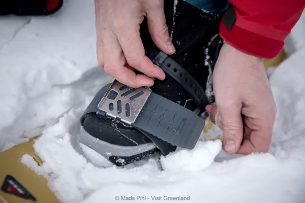 Strapping on snow shoes in East Greenland